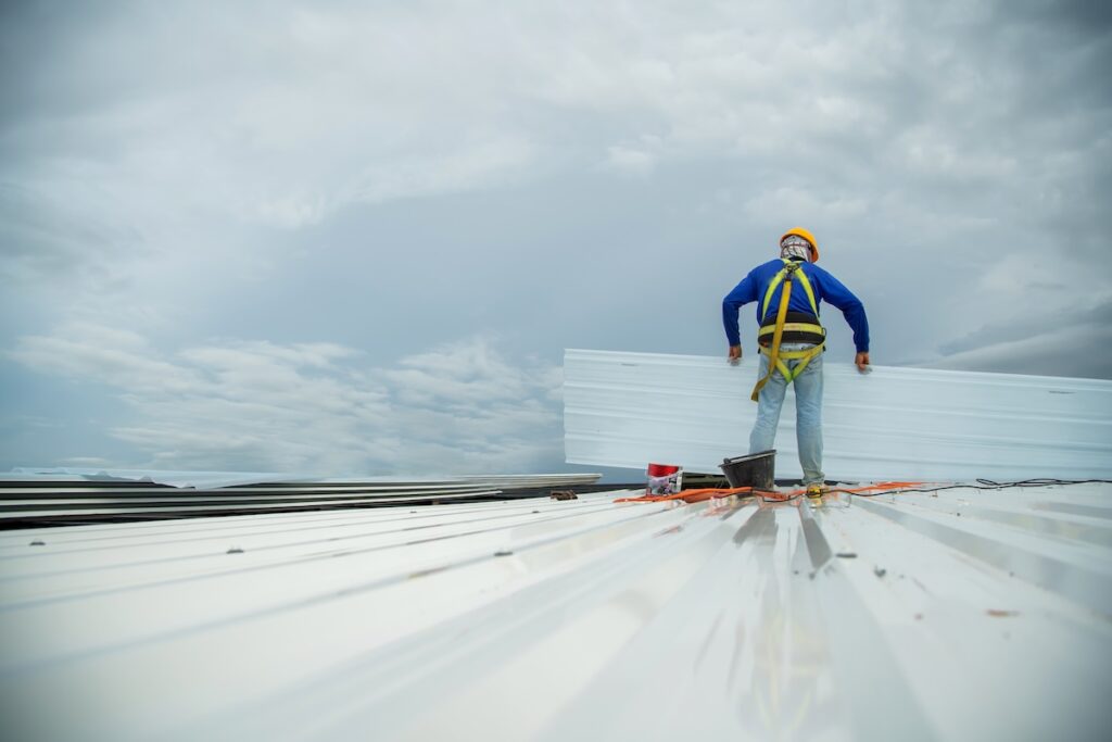 Roofer carrying panels onto commercial roof project